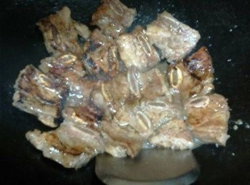 step6: 將瓁洗淨，燒熱瓁，沿瓁邊倒入1湯匙油煮熱（加油燒熱瓁，防止肉粘瓁）倒熱牛仔骨大火煎1分鐘