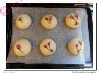 step8: 把櫻花放在麵包上, 放一塊牛油紙 / 焗爐墊, 再用另一個焗盤把麵團壓平。