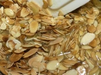 step2: 將牛油放入鍋內，用小火煮溶。加入柚子蜜、淡忌廉、砂糖拌勻，煮滾後熄火。倒入杏仁片，用膠刮刀攪拌均勻。