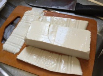 step1: 先將豆腐切成長方形，再切片; 獨子蒜拍去皮，切碎備用，咸蛋蒸熟後去殼切粒備用
