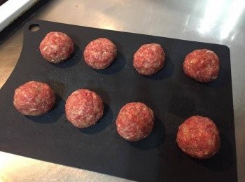 step2: 將肉團分成八等份不等（每顆直徑約5公分左右），將每份肉丸在兩手間丟來丟去拍打，可以增加肉丸的Q度，中間壓扁一點放入Cheddar起士塊或是Mozzarella起士絲，再包起來捏成圓形