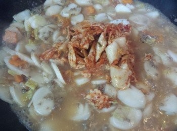 step6: 加入半碗水，煮滾後轉中火炆煮年糕一會，最後再加入泡菜，將年糕煮至軟身，放入蔥段拌勻即可。