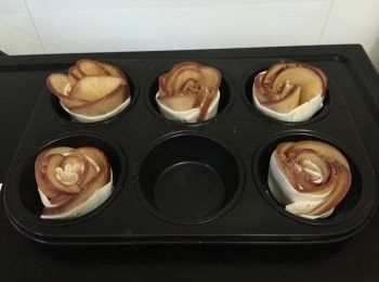 step3: 酥皮從雪櫃取出10分鐘備用，把酥皮分成5份長條型，把蘋果片擺放在酥皮上，塗上蜜糖及加上玉桂粉卷起成花卷型，然後放在焗盤上。