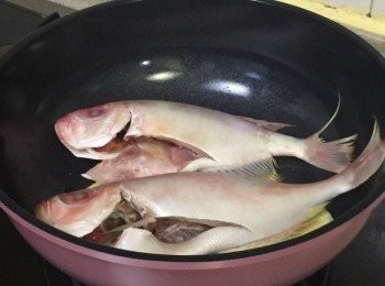 step2: 燒熱油鑊子，中大火爆香薑片後，加入魚煎至兩邊熟約5-8分鐘，煎魚期間於另一爐開火煲熱水，水滾後撞入煎香的魚中，關蓋大火滾起至魚湯成奶白色約15-20分鐘
