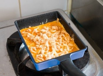 step4: 開火後待約 1 分鐘至鍋子有熱度，調至最小火，倒入蛋漿，鋪上芝士碎和豬肉鬆。