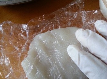 step8: 戴上膠手套,取1份粉糰,用1塊保鮮紙包住粉糰將粉糰按扁