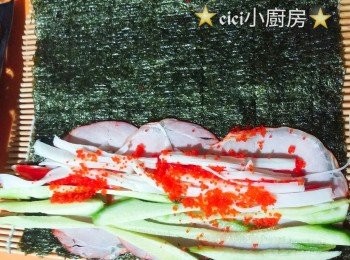 step2: 壽司席上鋪上壽司紫菜，將3片切片火腿放在紫菜上，再鋪上青瓜絲、 蟹柳絲、 蟹籽，用壽司席卷合成紫菜卷。是
