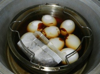 step3: 將蛋殼敲裂，加入水與調味料，水要蓋過蛋喔！水與醬油比例是5比1，我用的是有附茶葉的滷包，市面上也有賣沒加茶葉的滷包，大家可加入自己喜歡的茶，入電鍋3杯水蒸煮