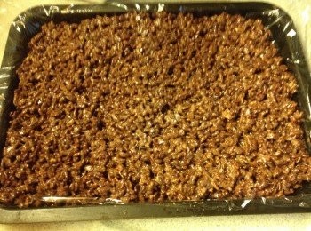 step4: 將保鮮紙放平放在焗盤或碟（建議用大而薄身的，切出來比較靚), 把可可米倒在焗盤上壓實