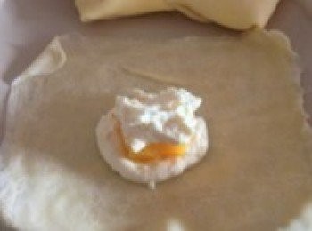 step7: 取一張麵餅，在中心鋪上一層奶油糊，再放一塊芒果條，再鋪上一層奶油糊。