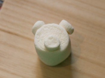 step4: 綿花糖小熊做法：再同樣方法剪開另一粒細綿花糖，於切口位點上已溶化之白朱古力，再如圖貼上大綿花糖上