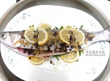 step3: 豆豉醬、蒜頭切碎，鹹檸檬切碎加少許糖拌勻，鮮檸檬切薄片，把這些材料舖在魚上(魚㡳舖蔥段)，下少許橄欖油，隔水以大火蒸10分鐘(水滾後才放魚)。