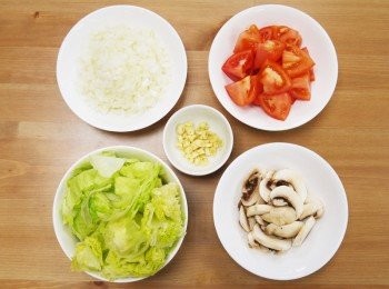 step1: 步驟1：
取碗放入蟹肉加白酒1匙浸泡，蒜洗淨切片，洋蔥洗淨切小丁，洋菇洗淨切片，胡蘿蔔洗淨去皮切小丁，萵苣洗淨切丁，牛番茄去蒂洗淨切塊備用。