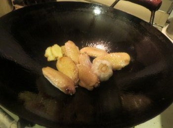 step1: 鸡用腌料腌至少20分钟。蒜头整粒用刀背大力啪扁。油锅爆香薑片后，放鸡件煎，煎完一面才翻另外一面煎