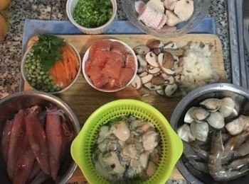 step2: 芹菜和蔥先用可飲用水洗淨後擦乾切花備用；紅蘿蔔切絲；洋蔥切丁；香菇切片；蛤蜊刷乾淨；鮮蚵用流動水輕輕洗淨；中卷剪去眼睛，並將身上的透明薄膜撕掉後洗淨；蝦子剪去眼睛、觸鬚和腳，並去除泥腸後洗淨。魚板切片；花枝丸切片；鮭魚去皮切塊。