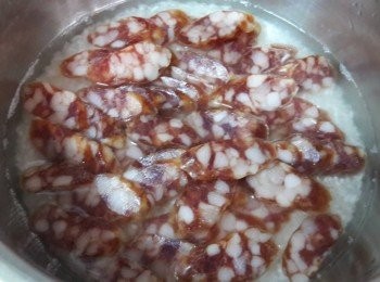 step2: 白米洗淨先浸泡十分鐘 , 再把切片的臘腸排放在上面 , 外鍋放一杯水煮熟