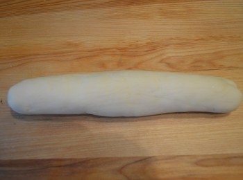 step12: 取出已醒的麵團放在桌上，然後用力推動，把麵團攤開，疊起，反覆搓揉，揉成一個長形的光滑麵團。