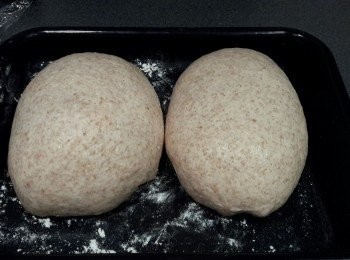 step5: 拿出麵糰，分成兩份，塑做圓形 （不用再搓麵糰的）放在烤盤內，用保鮮膜蓋好，再靜置45分鐘，作第二次發酵