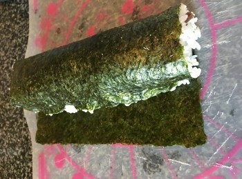 step4: 由頭部向尾部卷去，卷時要用手心握緊飯卷呀！直至卷起為止，卷好後掃上麻油，切件，曬上芝麻，完成！