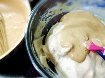 step6: 再將拌過的蛋黃糊 ，分次加入蛋白糊中輕柔拌勻即可。再倒入舖有烘焙紙的鍋具中，加入一些些的葡萄乾，就可準備開始蒸囉～