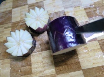 step2: 於每段茄子中間用刀仔三角斜方向地插入到茄子中間位置,然後搣開就會變成二朵花形茄子,將茄子用中火蒸15分鐘待茄子蒸淋