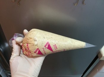 step6: 將混合物加入唧袋內，剪開唧袋，CUPCAKE模內加入底紙，將混合物唧入底紙中約1／3滿，（勿貪心加太多）