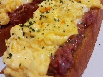 step2: 落油燒熱鑊熄火，離火待20秒左右降温後加入蛋液不斷攪拌成理想半熟狀態(期間未夠熟就放回爐上約5-10秒再離火不斷攪拌), 將滑蛋再放上吐司，灑上香草碎完成