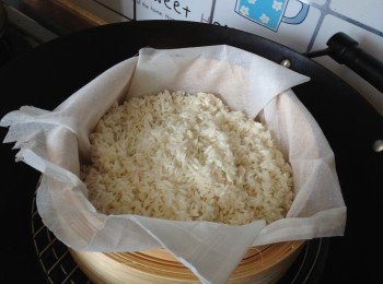 step3: -浸好的糯米放在舖好魚湯袋的蒸籠上蒸約15分鐘至飯約8,9成熟 (中途用唧壺噴小許水在米上，再用筷子把米攪鬆，再蒸)，之後離鑊用糖3/4茶匙，鹽1/2茶匙撈勻，令飯有點味，蓋上蒸籠蓋備用。
