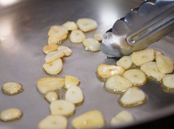 step3: 燒熱鑊，加入少許特純橄欖油，用小火把蒜片炒至微微金黃色。