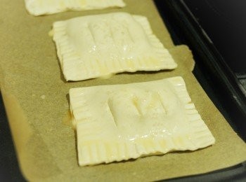 step7: 再在外層塗一層蛋液，灑少許紅糖在上面。將蘋果批放在鋪有烘焙紙的烤盤上，放入已預熱180度焗爐，焗約20分鐘或至表面金黃色即成！