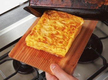 step9: 最後將表面煎至上色，並置於小砧板等取出。用砧板蓋住煎鍋，連同煎鍋一同翻轉，煎蛋的形狀便不會走樣。將玉子燒切成合口的大小後盛入器皿，附上蘿蔔泥。