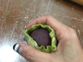 step15: 用虎口慢慢將餡料包好,並收口捏緊.捏好後轉正,用手掌或手指以輕壓的方式將蛋黃酥略微整型即可.