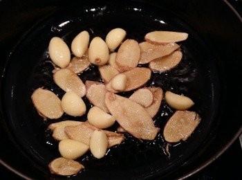 step2: 鍋裡倒入麻油,將蒜粒及薑片都下鍋,以小火慢慢煸香。喜歡吃辣一些,可先放入辣椒一起拌炒。