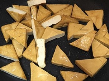 step6: 熱鍋後放入一些油，將豆干煎至表面起泡。