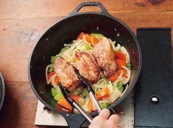 step5: 加入洋蔥、紅蘿蔔、芹菜與鹽拌炒至變得軟嫩。放上用鍋蓋煎好的3的豬排骨。