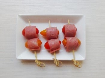step1: 三明治火腿片一片切成三小片,將小蕃茄輕劃一刀再塞入一端的火腿片,捲起用竹籤串起。