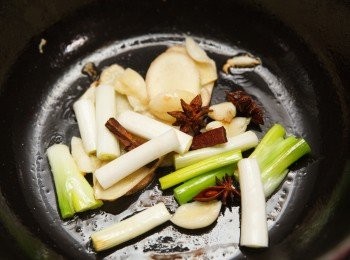step2: 鑄鐵鍋先預熱再轉中小火，倒入沙拉油後接著將蔥、薑、蒜與八角、桂皮下鍋爆香，要記得使用中小火即可，火苗切勿超過鍋底，炒的時候也請使用木質或矽膠工具輔助。