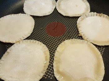 step6: 6、平底鍋加入一匙的沙拉油，熱鍋後再放入煎餅，用微火慢煎。