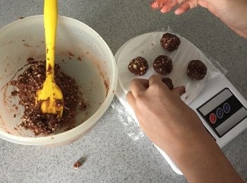 step3: 把麵團分成小份，約15g一份。滾圓後放在已鋪上牛油紙的烤盤上，輕輕壓平。在曲奇表示放上不同配料。