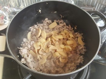 step4: 加入免治豬肉炒至半熟後贊少許酒，再加入蘑菇片炒勻。