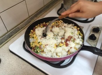 step4: 起熱鍋放入些許油，先加入香腸炒香後，再加入玉米及小黃瓜丁，略炒後，加入白飯翻炒，最後以鹽巴及胡椒調味，翻炒均勻後即可起鍋。