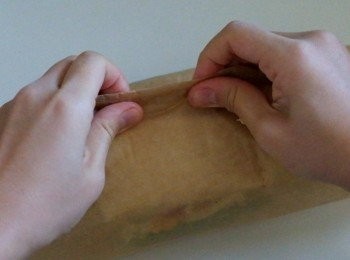 step7: 取兩端牛油紙，卷摺壓實三文治。