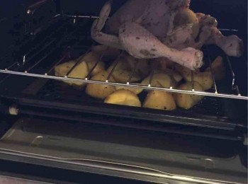 step3: 用預熱了200度的焗爐先焗十分鐘，然後反轉焗多十至15分鐘，最後用250度焗至表皮金黃香脆，約五分鐘。期間雞的精華會滴落薯仔下