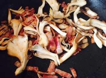 step3: 無須下油，放煙肉炒至出油。加入舞茸，放適量鹽及胡椒調味。舞茸炒熟後放入翡翠苗快炒至軟身。