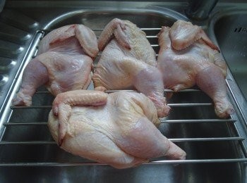 step2: 洗乾淨，用剪刀一開為二（成為四份）,  清理後要用架盛起，  讓血水留清，用廚紙徹底索乾水份,  每份雞（半隻）用1/2茶匙幼鹽塗勻,