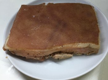 step3: 用鹽、黑胡椒和煙燻紅椒粉混合白酒，抹上豬肉的部份。返轉豬肉，皮向下放在碟上。然後倒上白醋，浸泡豬皮部份。放入雪櫃，醃六小時以上。取出抹去白醋，再鬆針，之後用蘇打粉搽滿豬皮。用一比一的鹽與白醋的醃料塗在豬皮上。再放入雪櫃，醃一夜。抽乾豬皮部份的水份。