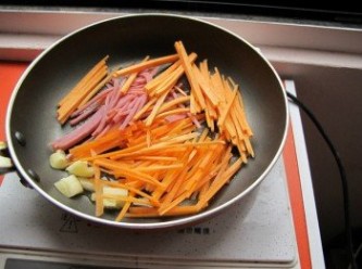 step2: 使用一大匙油熱鍋後，將地瓜絲、火腿絲、紅蘿蔔絲、蒜頭下鍋爆香翻炒