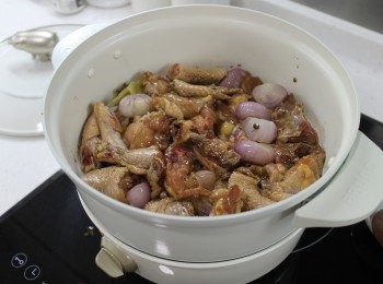 step4: 放入雞件煎香，沿鍋邊倒入兩湯匙紹興酒添香。