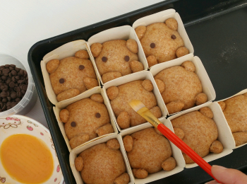 step6: 塗上蛋液後，可用入爐朱古力粒做眼睛。
放入已預熱至180℃的焗爐中，焗約15分鐘至麵包上色。