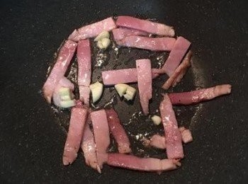 step3: 炒鍋燒熱，放入適量的油，炒香煙燻火腿和蒜末。